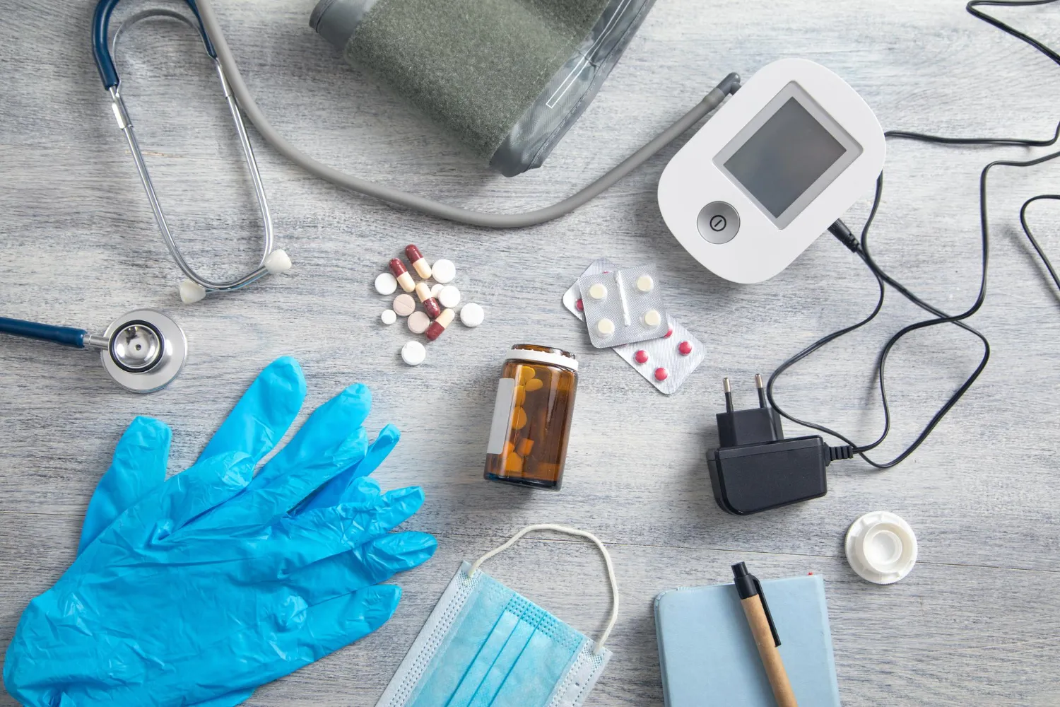 Medical equipment, including a blood pressure monitor, stethoscope, medications, gloves, and a face mask, arranged on a table to represent essential Medical Supply Jacksonville products and healthcare equipment.