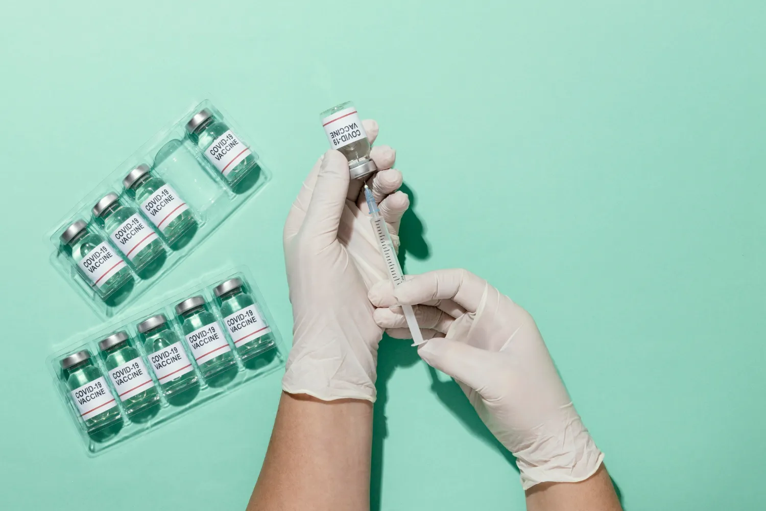 Healthcare professional preparing vaccinations from COVID-19 vaccine vials.