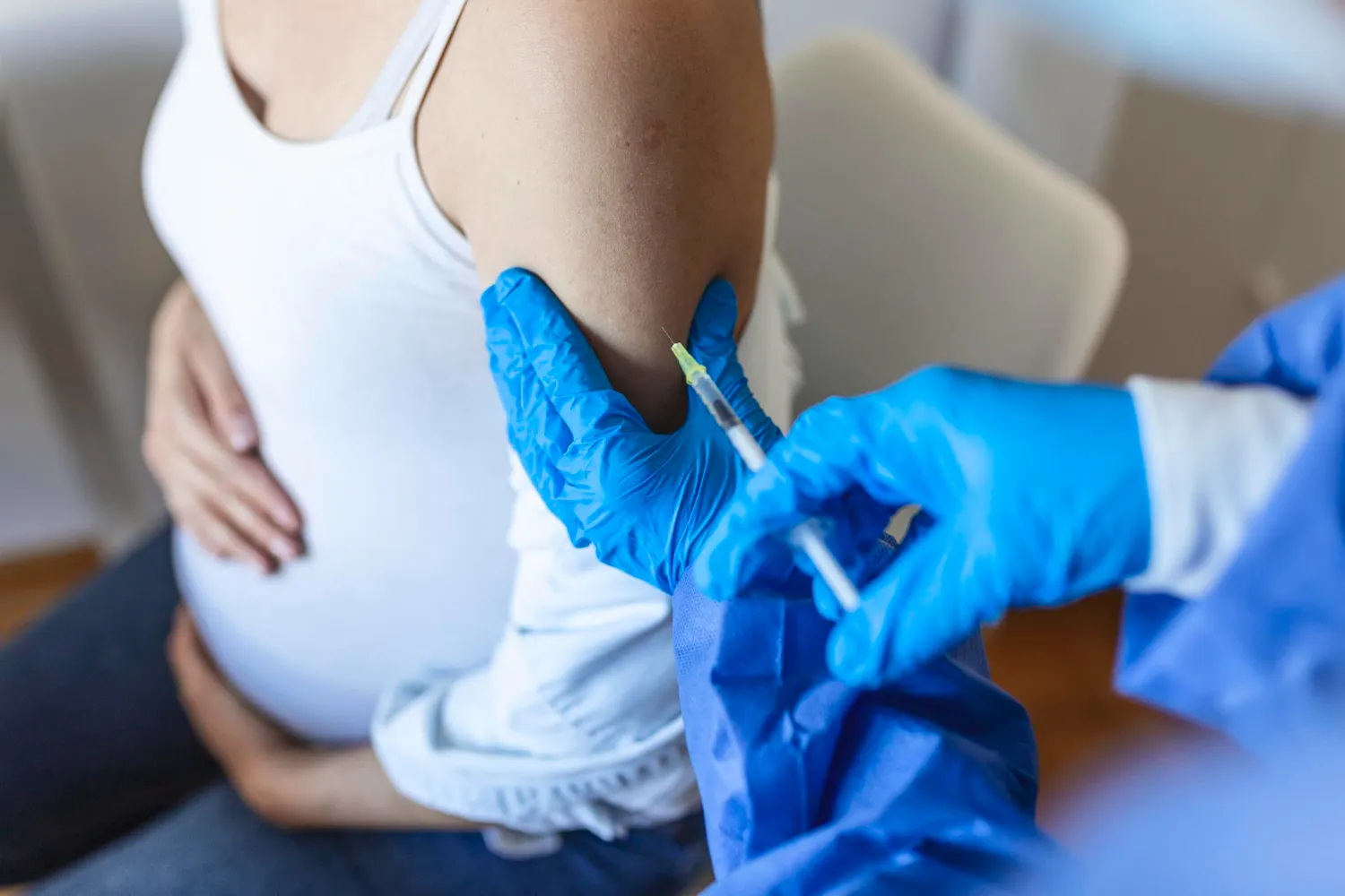Healthcare professional administering a vaccine to a pregnant woman, highlighting preventive care and immunization near me services.