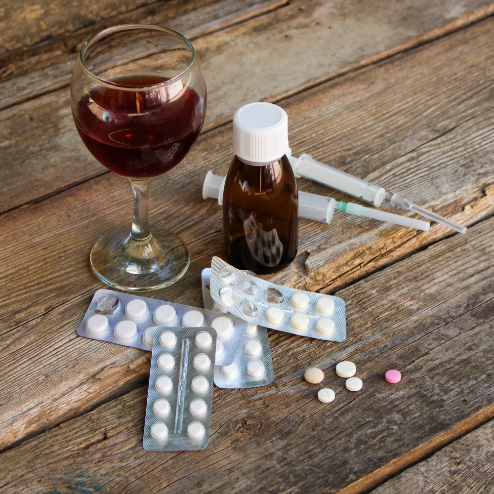 Alcohol and prescription pills on table highlighting risks of mixing generic medications with alcohol