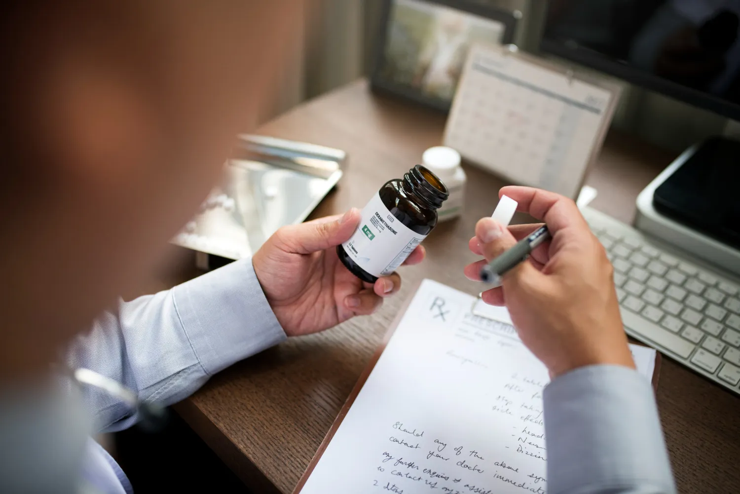 Healthcare professional reviewing a prescription bottle and medication records, supporting prescription synchronization services through a comprehensive Med Sync program.