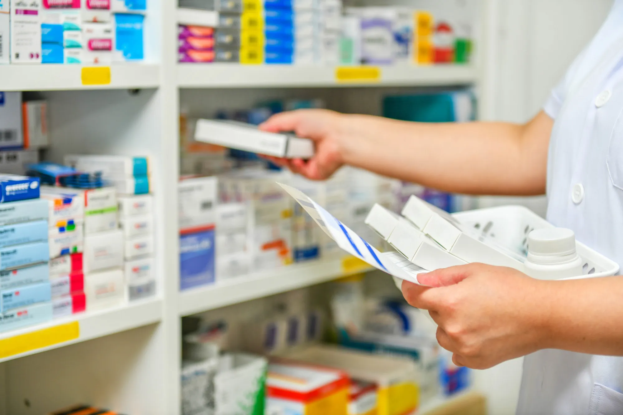 Pharmacist organizing and reviewing vitamin and supplement products in a pharmacy, representing vitamins and supplements in Jacksonville.