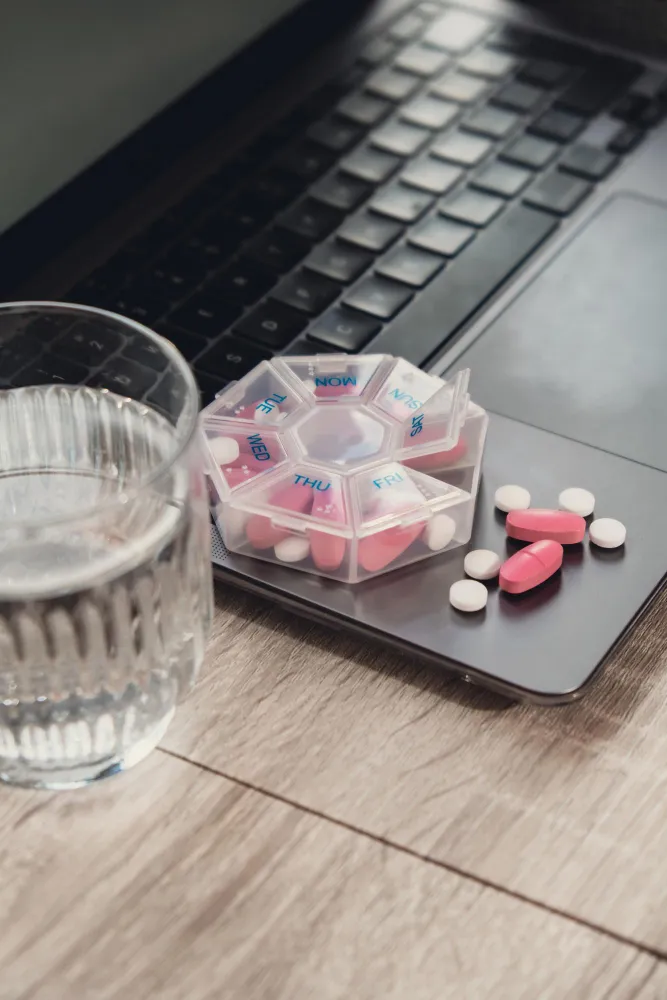 Person organizing daily vitamins and supplements with guidance from pharmacist recommended supplements.