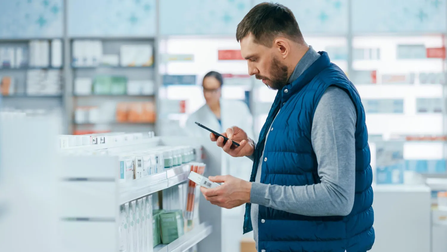 Patient reviewing medications in a pharmacy with a pharmacist nearby, highlighting medication management pharmacy support.