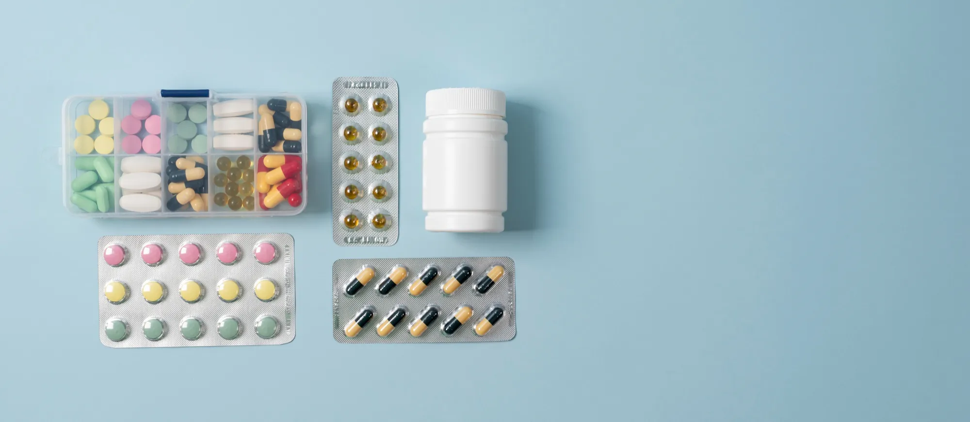 Assorted medications in different containers representing medication packaging services.