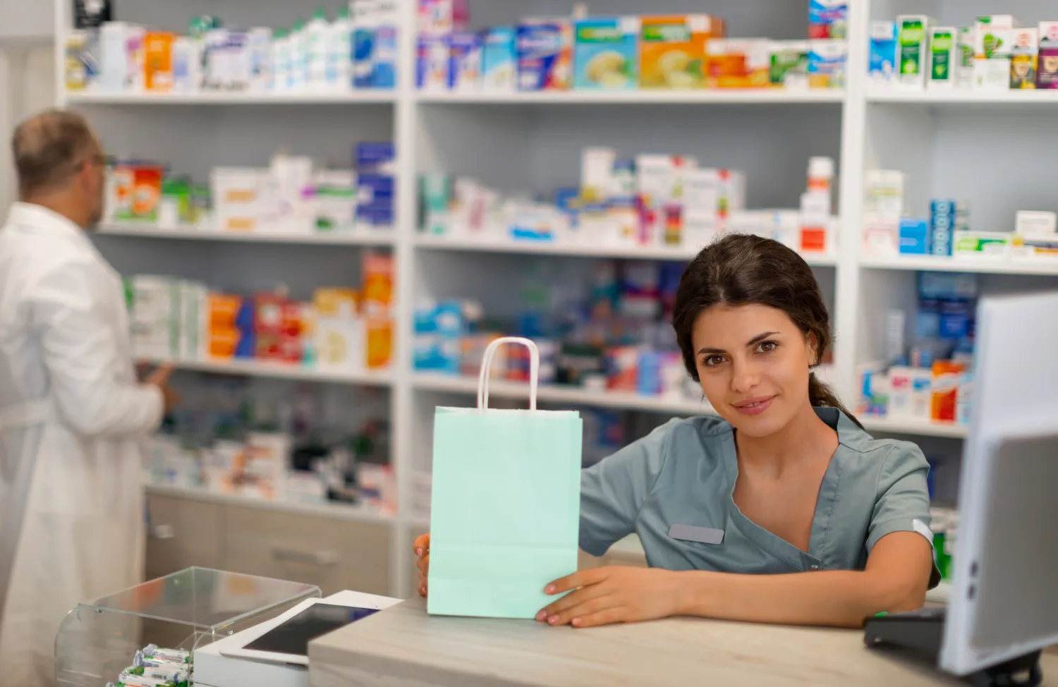 Pharmacist speaking with a customer at a pharmacy in Jacksonville FL about medication needs.