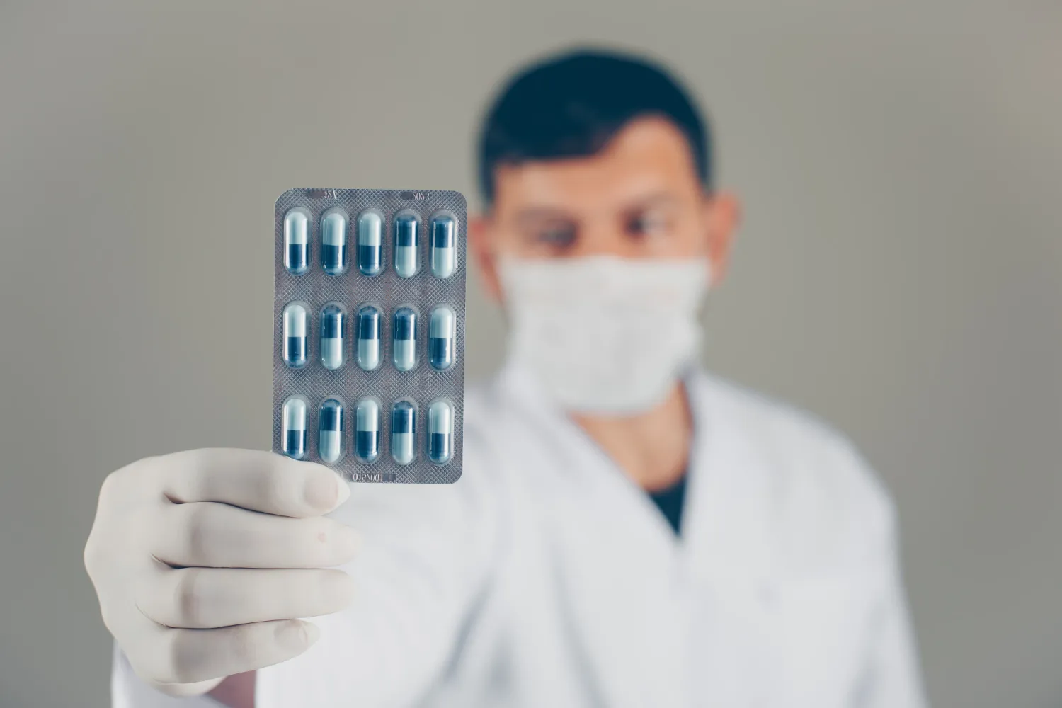 Pharmacist holding a blister pack of capsules, illustrating special medication packaging for organized and convenient medication management.